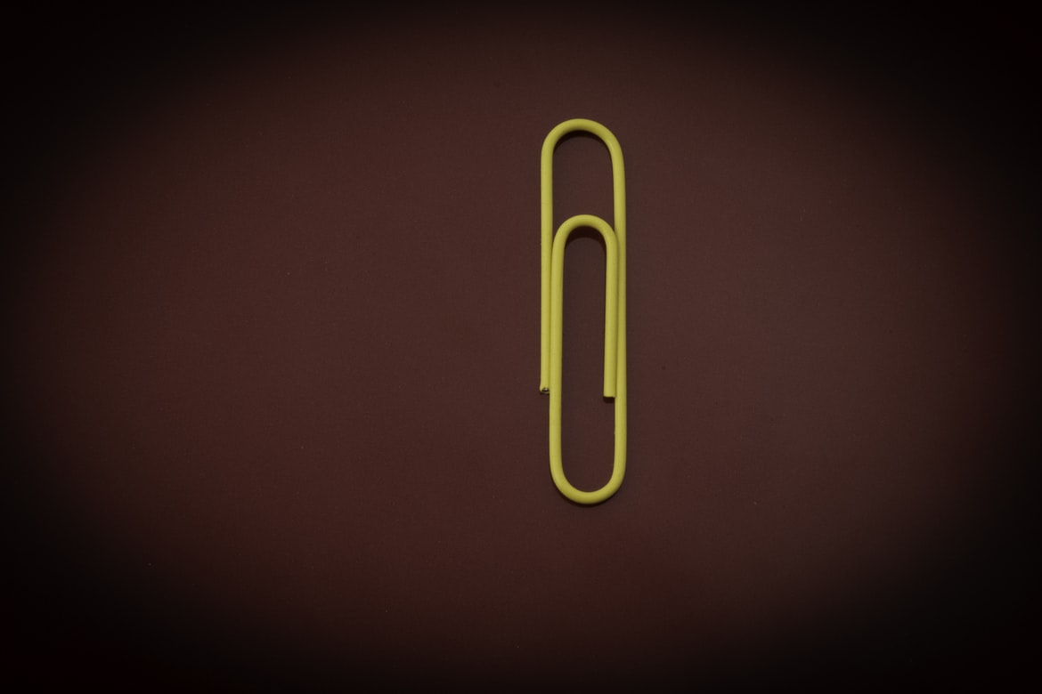 a yellow paper clip on a dark red background