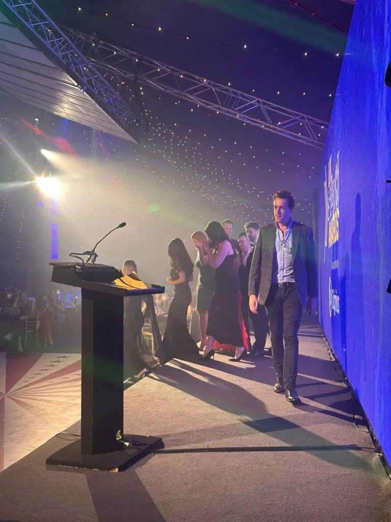 Owain Lloyd-Williams walking on stage at search awards